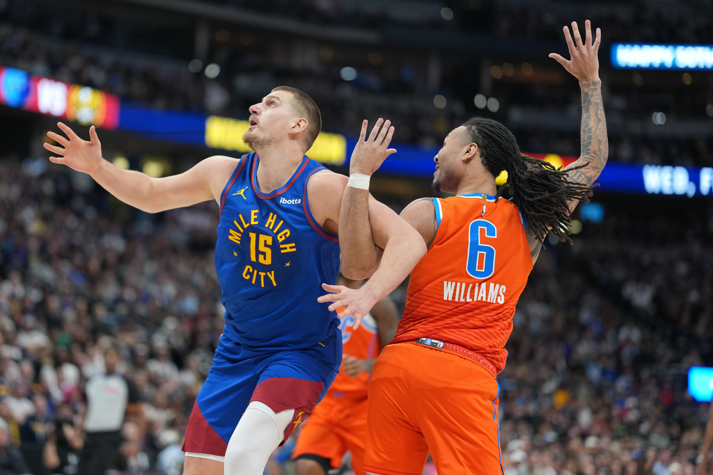 Denver Nuggets center Nikola Jokić, left, gets tangled up with Oklahoma City Thunder forward Jaylin Williams in the first half of an NBA basketball game, Sunday, Feb. 1, 2026, in Denver. (AP Photo/David Zalubowski)