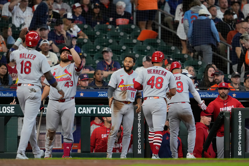 St. Louis Cardinals' Jordan Walker (18), designated hitter Iván Herrera (48), and Ramón Urías (29) return to the dugout after scoring during the tenth inning of a baseball game against the Houston Astros in Houston, Sunday, April 19, 2026. (AP Photo/Ashley Landis)
