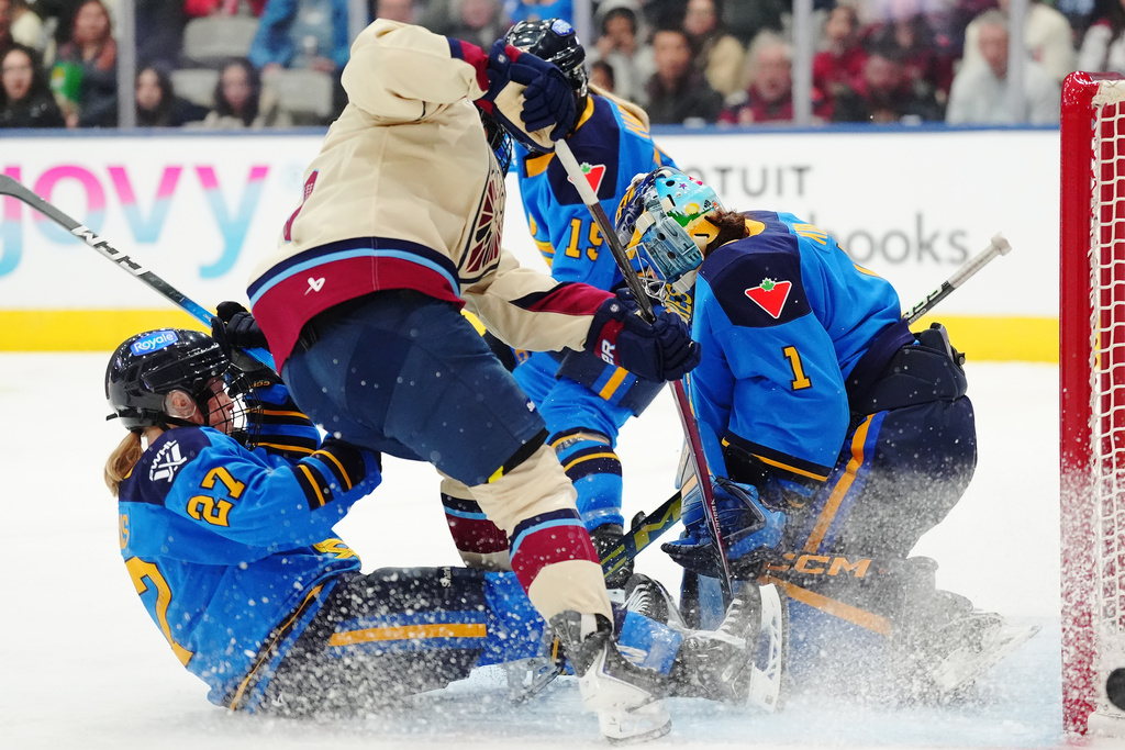Montreal Victoire's Lina Ljungblom, second left, scores on Toronto Sceptres goaltender Raygan Kirk (1) as Emma Maltais (27) slides during the third period of a PWHL hockey game in Toronto on Tuesday, March 3, 2026. (Frank Gunn/The Canadian Press via AP)