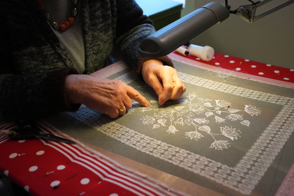 A woman demonstrates lacemaking in the Beguinage of Lier, Belgium, during an open day on Saturday, March 28, 2026. (AP Photo/Virginia Mayo)