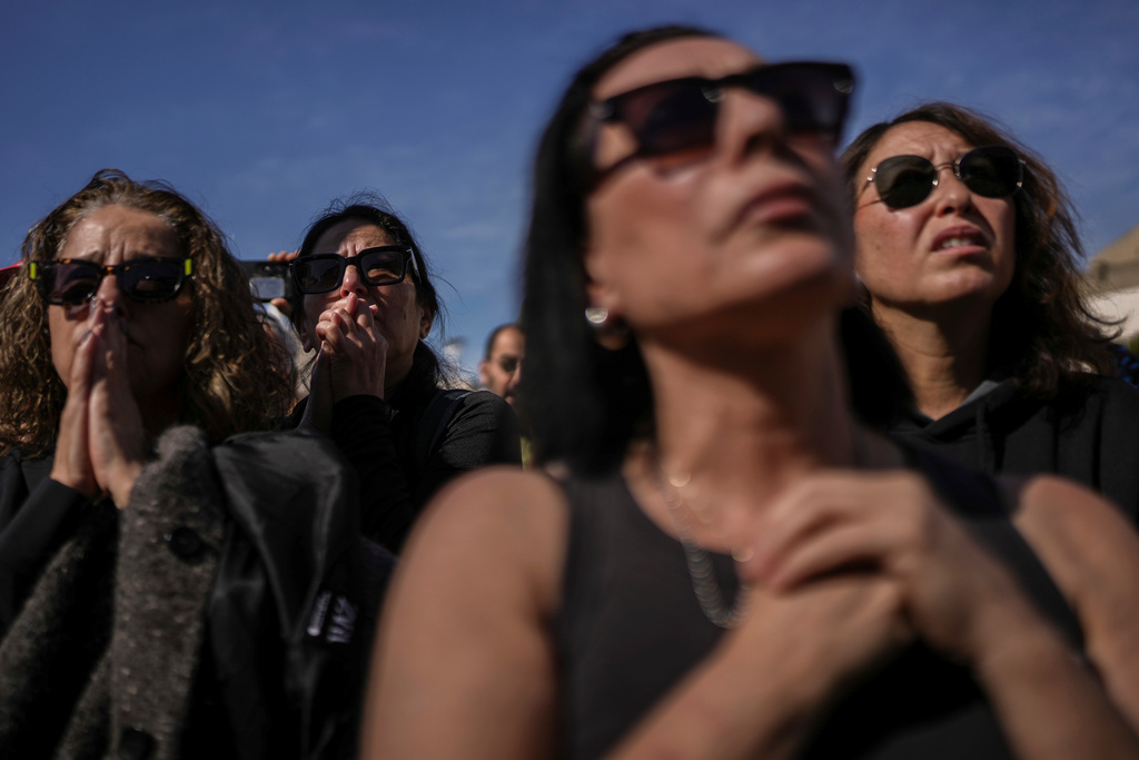 People watch a live Gaza broadcast of the release of three Israeli hostages during a gathering at "Hostages Square" in Tel Aviv, Israel, Saturday, Feb. 15, 2025. (AP Photo/Oded Balilty)