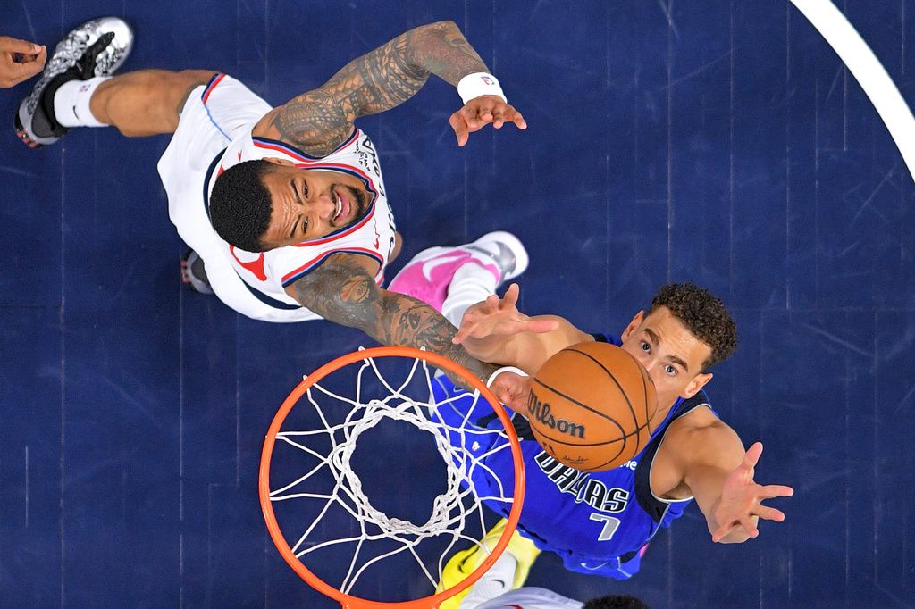 Los Angeles Clippers forward John Collins, left, and Dallas Mavericks forward Dwight Powell reach for a rebound during the first half of an NBA basketball game Tuesday, April 7, 2026, in Inglewood, Calif. (AP Photo/Mark J. Terrill)