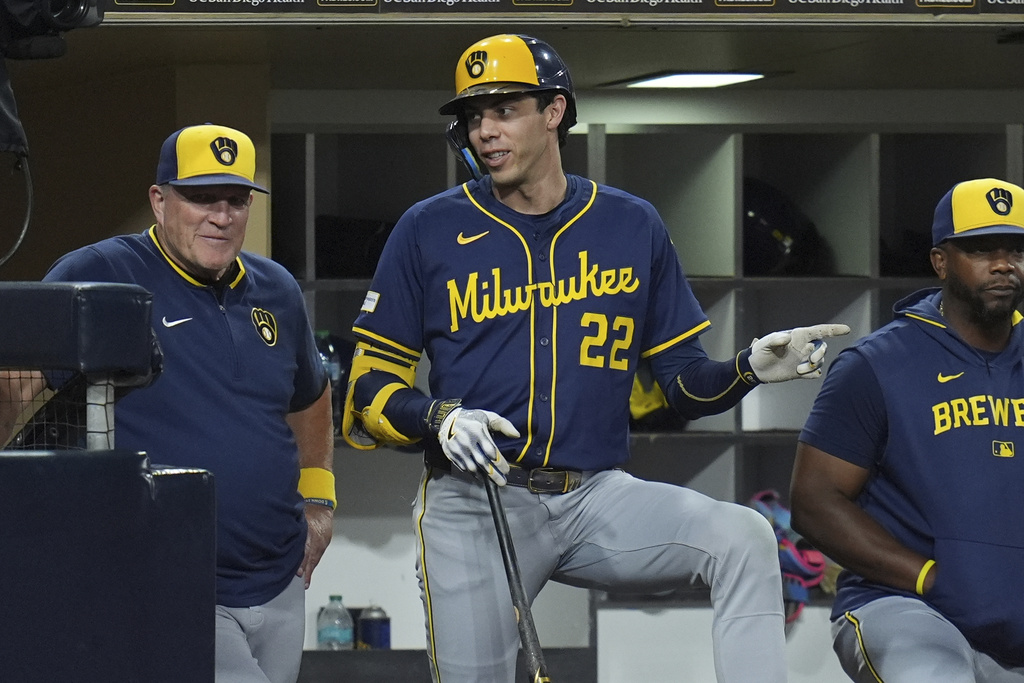 Milwaukee Brewers' Christian Yelich (22) talks with manager Pat Murphy in the dugout during the fourth inning of a baseball game against the San Diego Padres Monday, Sept. 22, 2025, in San Diego. (AP Photo/Gregory Bull)