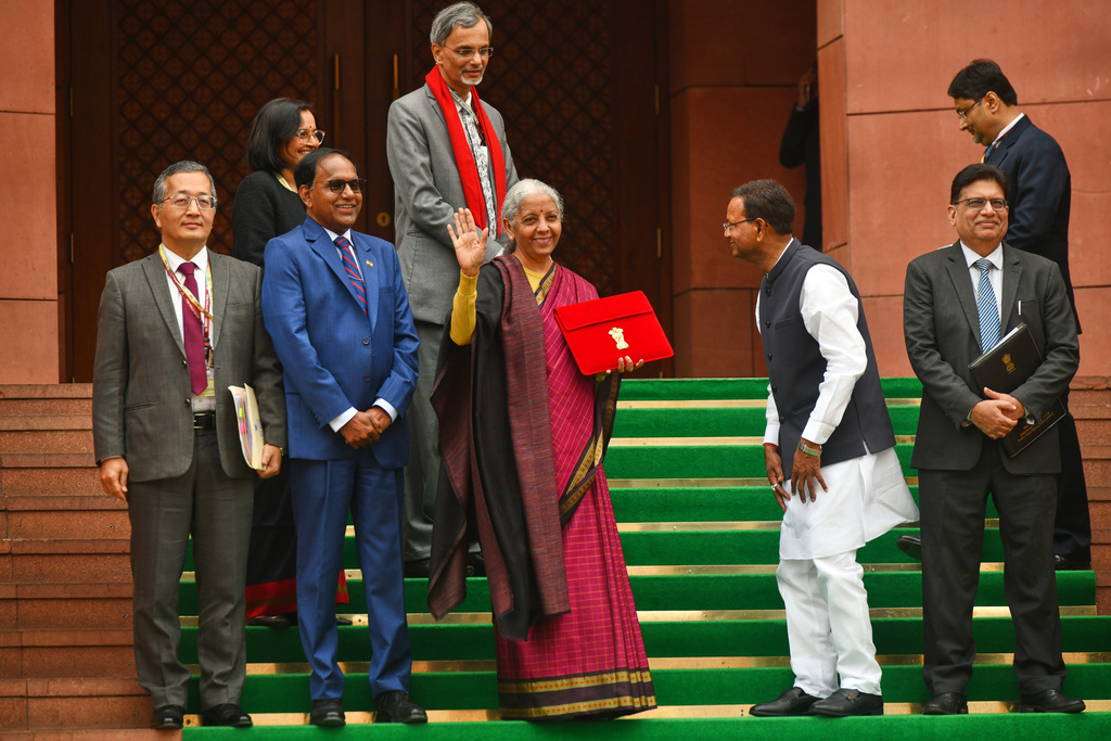 Indian Finance Minister Nirmala Sitharaman, center, displays a red folder containing the Union Budget 2026-27 at the steps of the parliament house before tabling it, in New Delhi, India, Sunday, Feb. 1, 2026. (AP Photo)