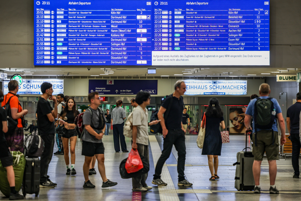 Passengers line up at the DB information desk at the Duisburg train station, Tuesday, June 23, 2026. (Christoph Reichwein/dpa via AP)