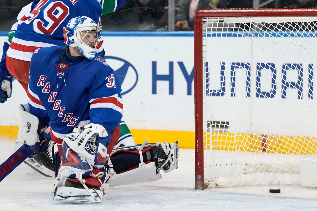The puck shot by Vancouver Canucks left wing Liam Ohgren (92) goes into the goal past New York Rangers goaltender Jonathan Quick (32) during the second period of an NHL hockey game, Tuesday, Dec. 16, 2025, in New York. (AP Photo/Yuki Iwamura)