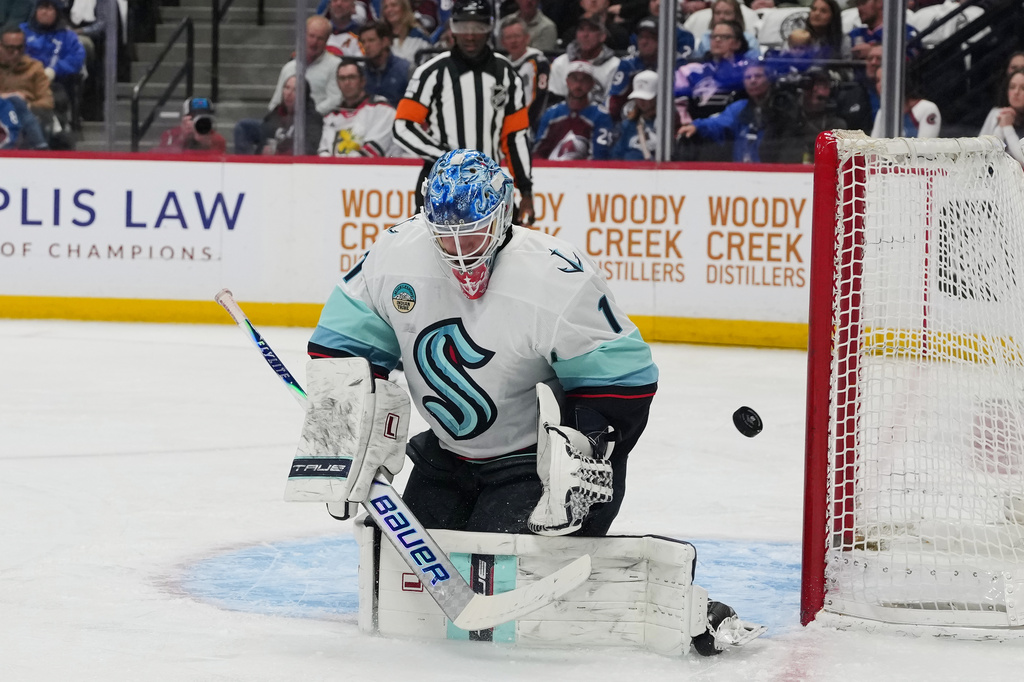 Seattle Kraken goaltender Victor Ostman deflects a shot in the first period of an NHL hockey game against the Colorado Avalanche, Thursday, April 16, 2026, in Denver. (AP Photo/David Zalubowski)