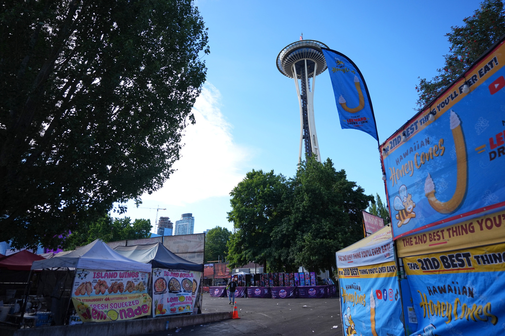 The U.S. flag flies at half staff at the Space Needle as cleanup continues the day after a shooting at Seattle Center during the Bite of Seattle food festival, Monday, July 27, 2026. (AP Photo/Lindsey Wasson)