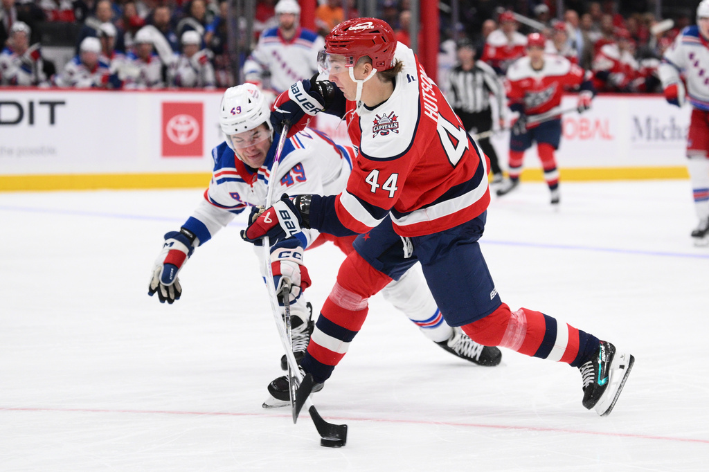 Washington Capitals defenseman Cole Hutson (44) shoots against New York Rangers right wing Jaroslav Chmelar (49) during the first period of an NHL hockey game, Friday, Oct. 9, 2026, in Washington. (AP Photo/Nick Wass)