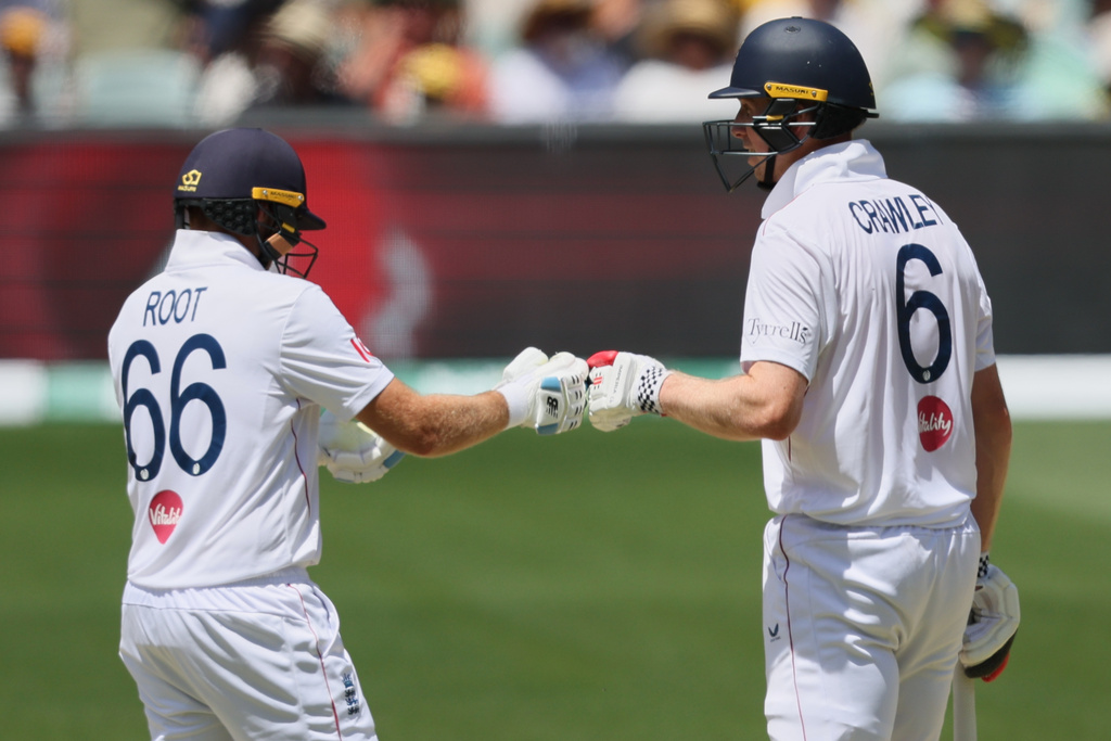 England batsmen Zak Crawley, right, and Joe Root gesture during play on day four of the third Ashes cricket test between England and Australia in Adelaide, Australia, Saturday, Dec. 20, 2025. (AP Photo/James Elsby)