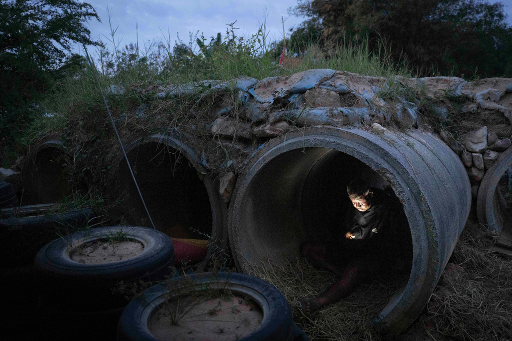 A Thai resident who fled clashes between Thai and Cambodian soldiers, uses mobile phone while taking shelter in Buriram province, Thailand, Tuesday, Dec. 9, 2025. (AP Photo/Wason Wanichakorn)
