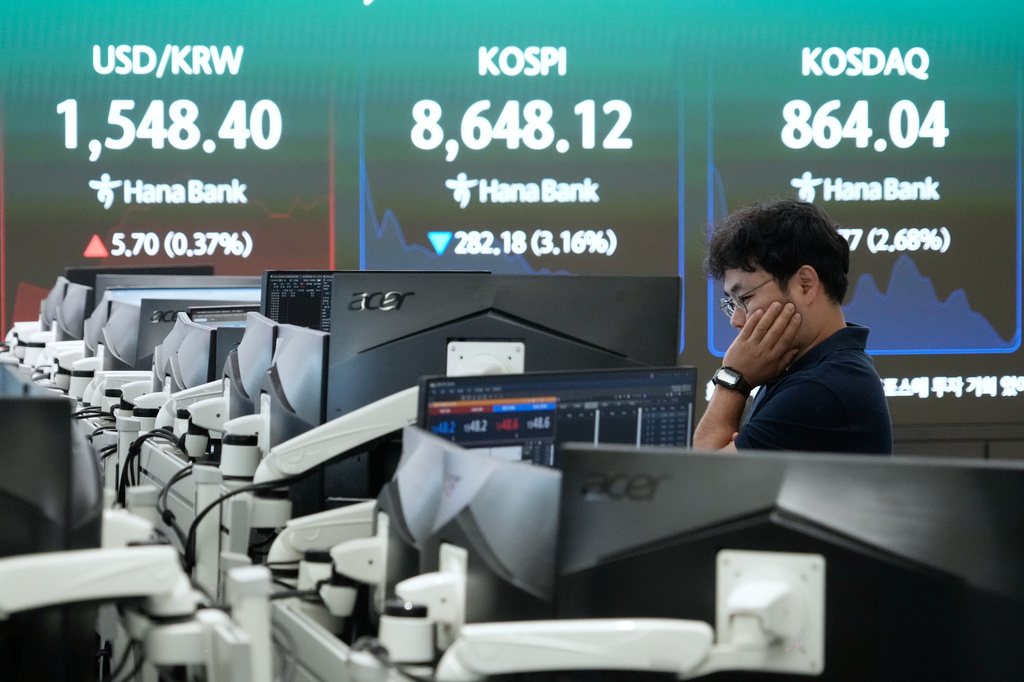 A currency trader watches monitors near a screen showing the Korea Composite Stock Price Index (KOSPI) and the foreign exchange rate between U.S. dollar and South Korean won at the foreign exchange dealing room of the Hana Bank headquarters in Seoul, South Korea, Friday, June 26, 2026. (AP Photo/Ahn Young-joon)