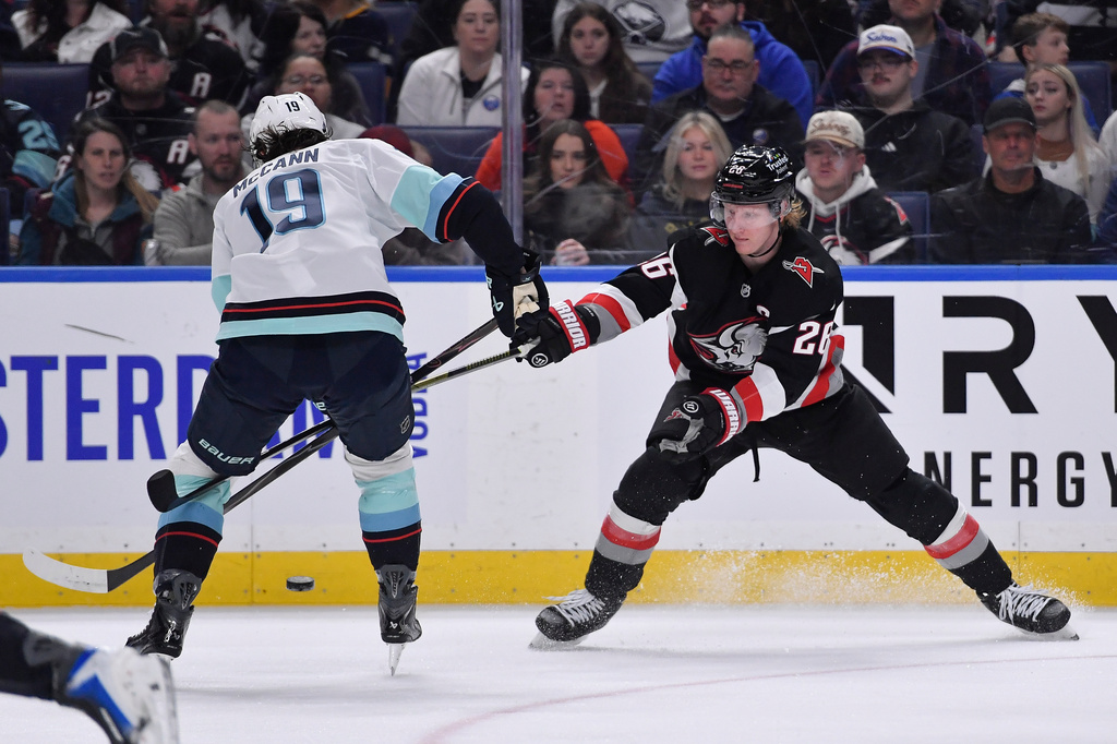 Buffalo Sabres defenseman Rasmus Dahlin, right, defends against Seattle Kraken left wing Jared McCann, left, during the first period of an NHL hockey game Saturday, March 28, 2026, in Buffalo, N.Y. (AP Photo/Adrian Kraus)