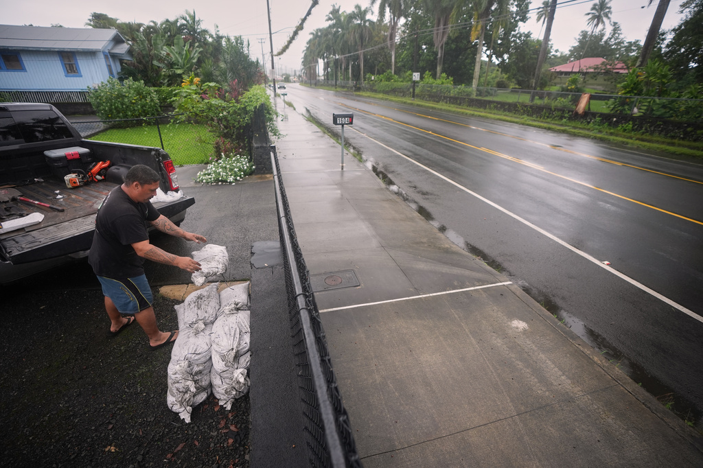 Louie Taasan places sand bags along his driveway as Hurricane Nolo sits nearby Friday, Sept. 25, 2026, in Hilo, Hawaii. (AP Photo/Gregory Bull)