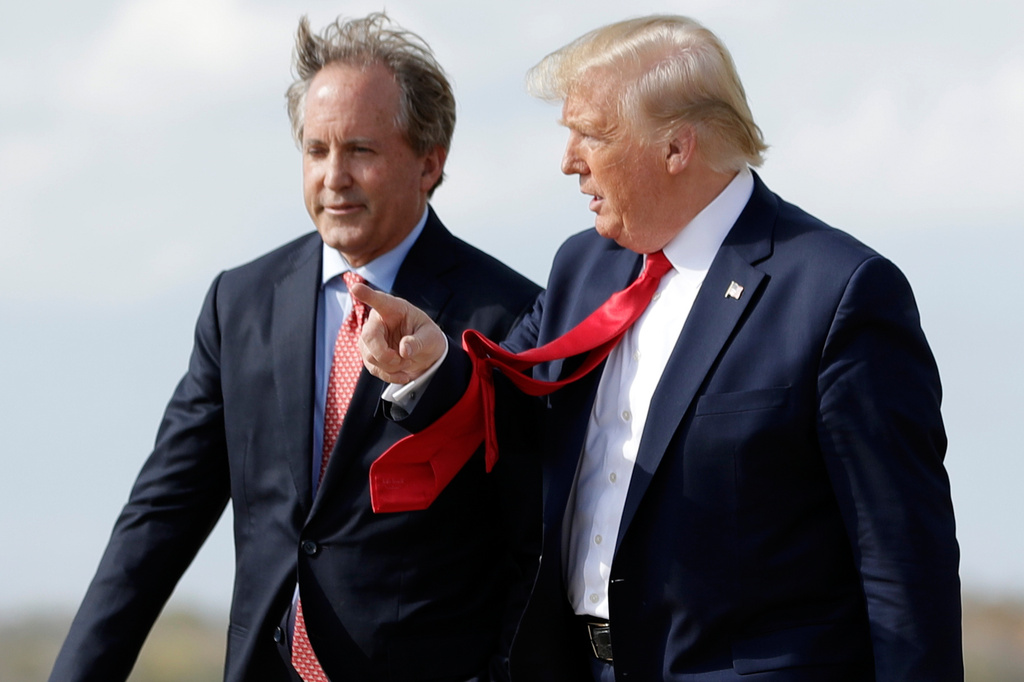 FILE - President Donald Trump walks with Texas Attorney General Ken Paxton, left, at Austin-Bergstrom International Airport in Austin, on Wednesday, Nov. 20, 2019. (AP Photo/Evan Vucci, File)