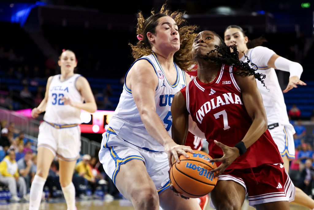 Indiana guard Jerni Kiaku (7) drives against UCLA guard Charlisse Leger-Walker, center, as UCLA forward Angela Dugalić (32) watches during the first half of an NCAA college basketball game, Sunday, Feb. 15, 2026, in Los Angeles. (AP Photo/Jessie Alcheh)