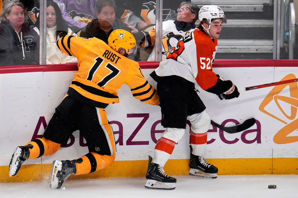 Pittsburgh Penguins' Bryan Rust (17) collides with Philadelphia Flyers' Denver Barkey (52) during the first period of Game 5 in the first round of an NHL hockey Stanley Cup playoff series in Pittsburgh, Monday, April 27, 2026. (AP Photo/Gene J. Puskar)