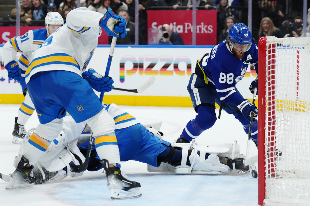 Toronto Maple Leafs' William Nylander (88) scores the game-winning goal against St. Louis Blues goaltender Jordan Binnington (50) during overtime of an NHL hockey game in Toronto on Tuesday, Nov. 18, 2025. (Nathan Denette/The Canadian Press via AP)