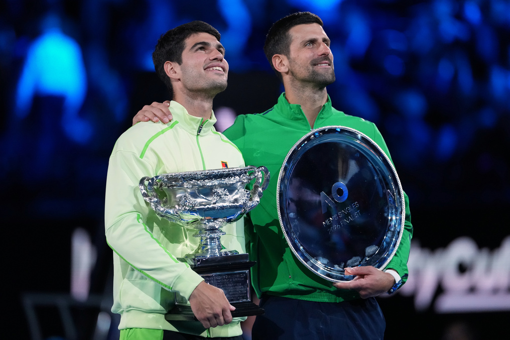 Carlos Alcaraz, left, of Spain holds the Norman Brookes Challenge Cup after defeating Novak Djokovic of Serbia in the men's singles final at the Australian Open tennis championship in Melbourne, Australia, Sunday, Feb. 1, 2026. (AP Photo/Aaron Favila)