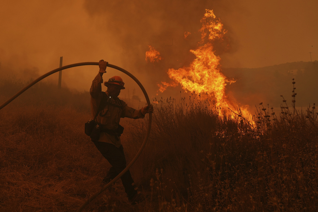 A firefighter battles the Canyon Fire on Thursday, Aug. 7, 2025, in Hasley Canyon, Calif. (AP Photo/Marcio Jose Sanchez)