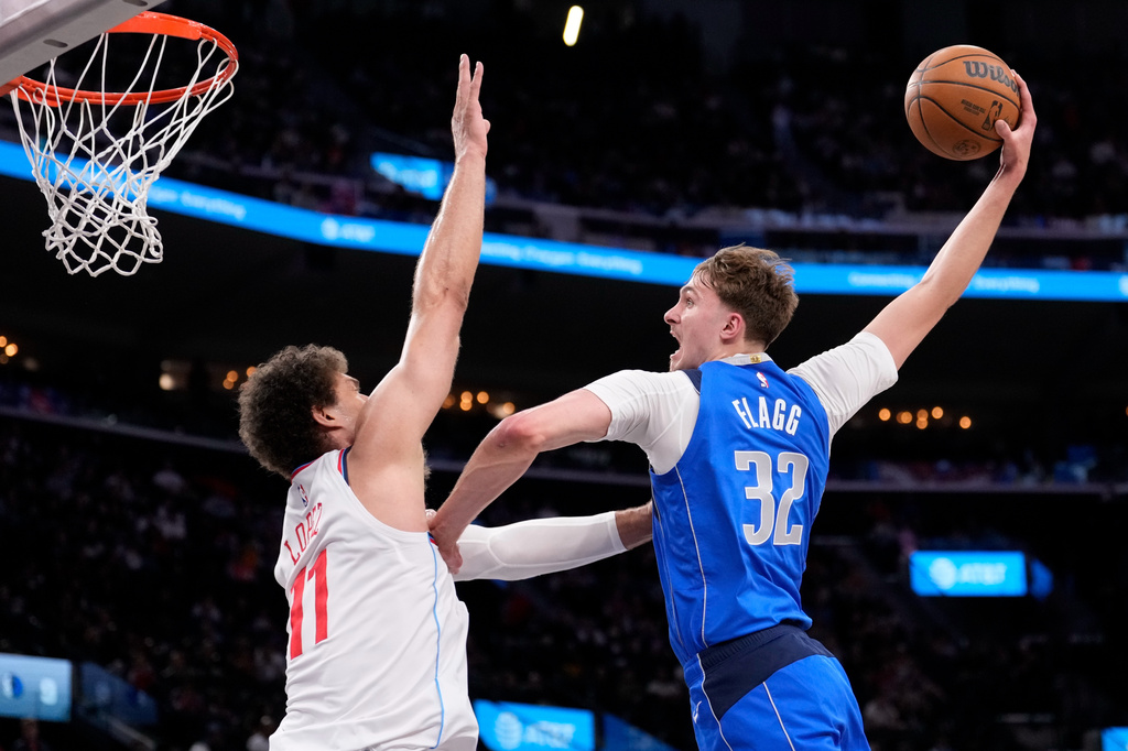 Dallas Mavericks forward Cooper Flagg, right, dunks as Los Angeles Clippers center Brook Lopez defends during the first half of an NBA basketball game Tuesday, April 7, 2026, in Inglewood, Calif. (AP Photo/Mark J. Terrill)