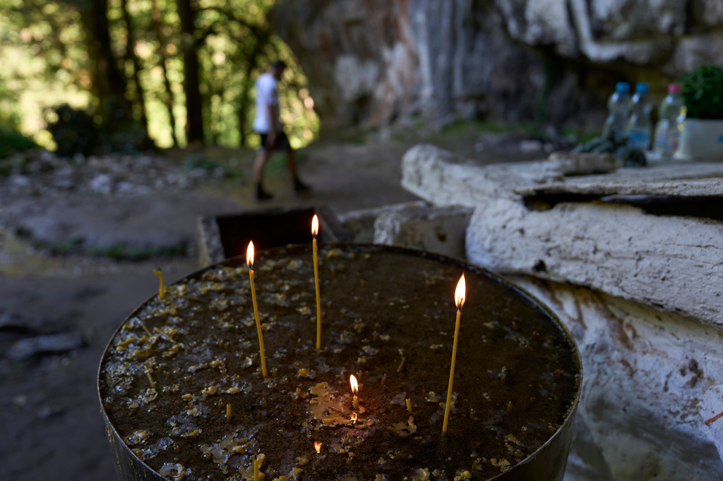 Candles burn outside a chapel at the Holy Cave of St. Dionysios in the Enipeas Gorge on Mount Olympus in northern Greece, Tuesday, July 14, 2026. (AP Photo/Petros Giannakouris)