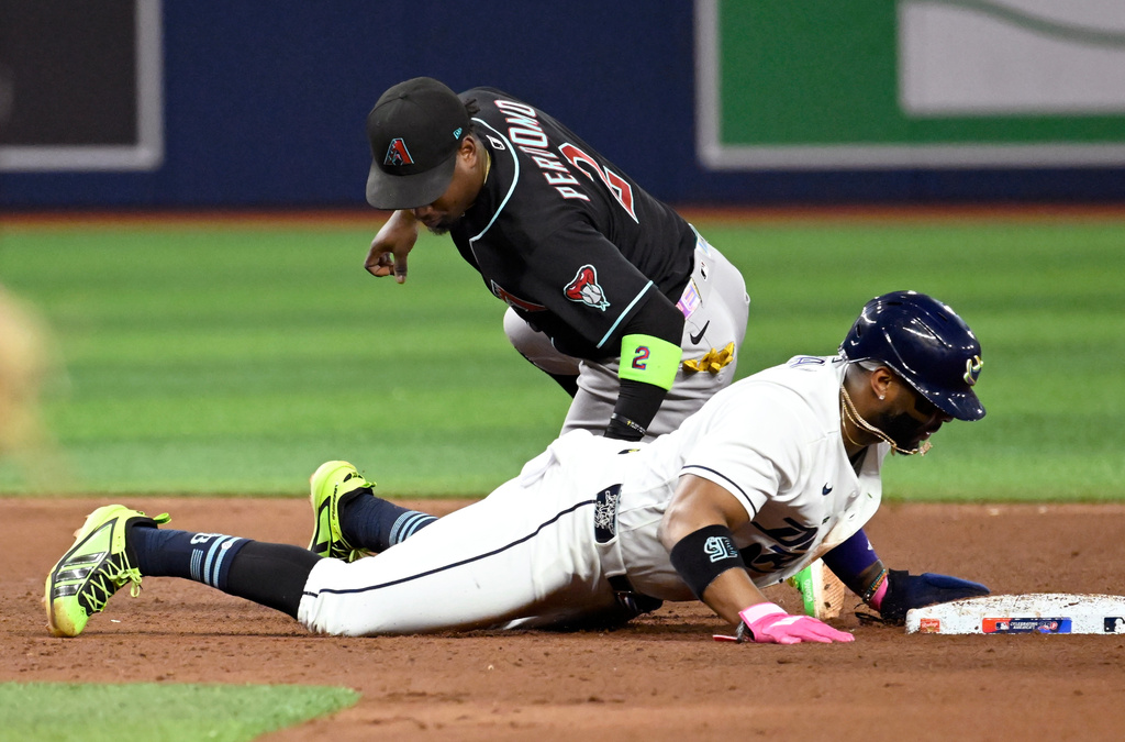 Tampa Bay Rays Yandy Díaz, bottom, gets safely back to second base before a tag by Arizona Diamondbacks shortstop Geraldo Perdomo, top, during the fourth inning of a baseball game Friday, June 26, 2026, in St. Petersburg, Fla. (AP Photo/Jason Behnken)