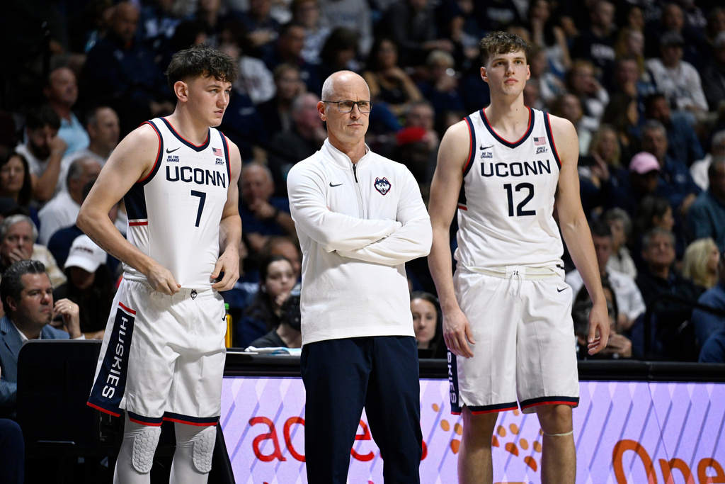 UConn head coach Dan Hurley, center, watches play with guard Jacob Furphy (7) and center Eric Reibe (12) during the first half of an exhibition NCAA college basketball game against Boston College, Monday, Oct. 13, 2025, in Uncasville, Conn. (AP Photo/Jessica Hill)