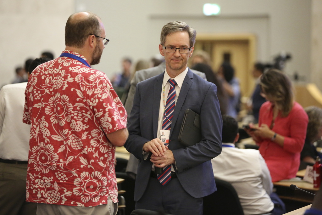 John Thompson, of the U.S. Department of State, right, speaks with Dennis Clare, legal advisor to Micronesia's delegation, after a meeting for delegates to the plastic pollution treaty talks in Geneva, Switzerland, convened and adjourned in less than a minute late on Thursday, August 14, 2025. (AP Photo/Jennifer McDermott)