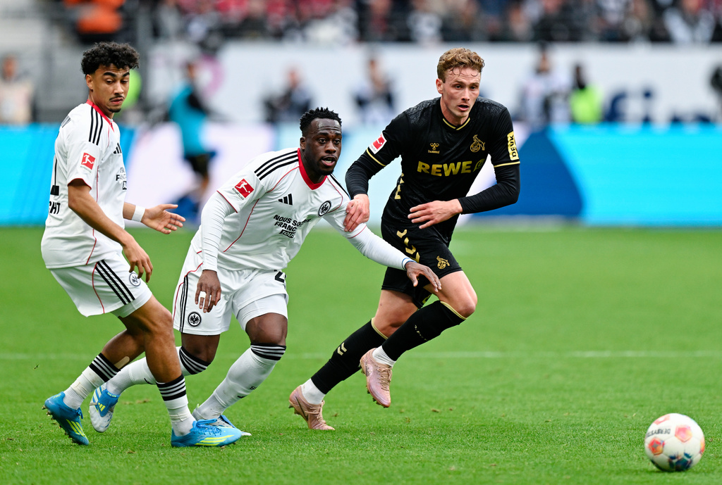 Cologne's Sebastian Sebulonsen, right, and Frankfurt's Nathaniel Brown, left, and Arnaud Kalimuendo battle for the ball during the German Bundesliga soccer match between Eintracht Frankfurt and 1. FC Cologne in Frankfurt, Germany, Sunday, April 5, 2026. (Uwe Anspach/dpa via AP)
