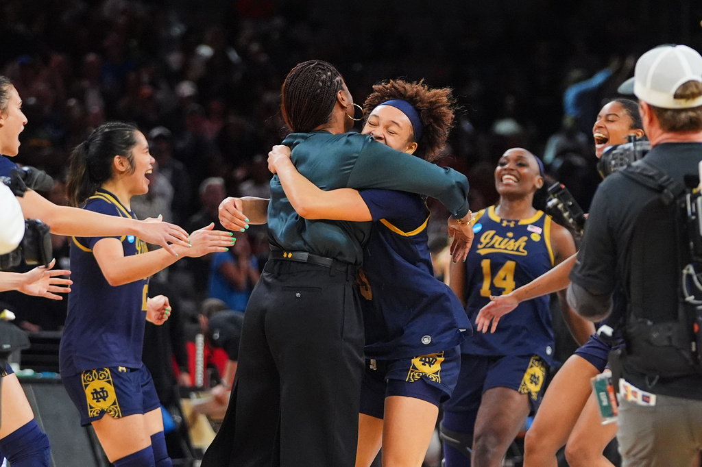 Notre Dame head coach Niele Ivey, center left, and Hannah Hidalgo, center right, celebrate the team's win against Vanderbilt in the Sweet 16 of the NCAA college basketball tournament, Friday, March 27, 2026, in Fort Worth, Texas. (AP Photo/LM Otero)