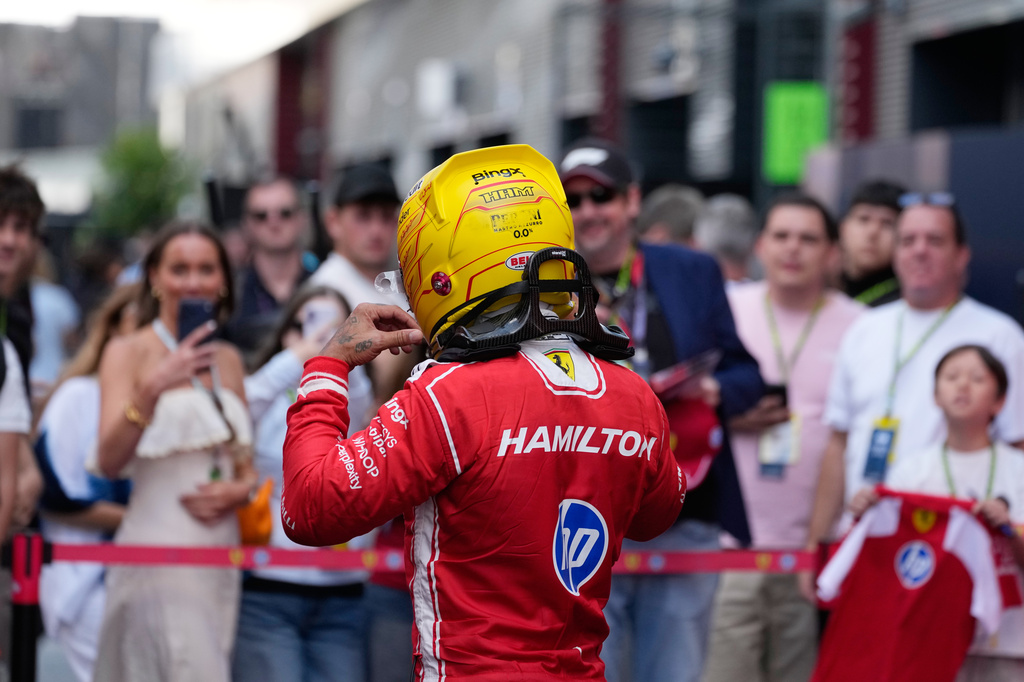 Ferrari driver Lewis Hamilton of Britain walks past supporters after the first free practice ahead of Sunday's Formula One Hungarian Grand Prix auto race, at the Hungaroring racetrack in Mogyorod, near Budapest, Hungary, Friday, July 24, 2026. (AP Photo/Darko Bandic)