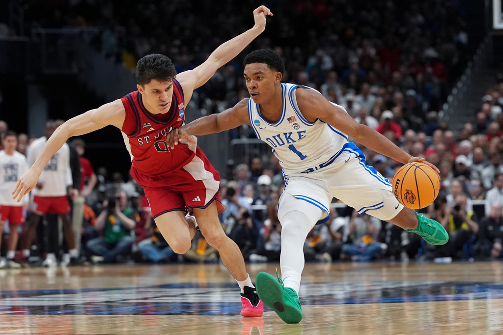 Duke guard Caleb Foster (1) drives past St. John's guard Dylan Darling (0) during the second half in the Sweet 16 of the NCAA college basketball tournament, Friday, March 27, 2026, in Washington. (AP Photo/Stephanie Scarbrough)