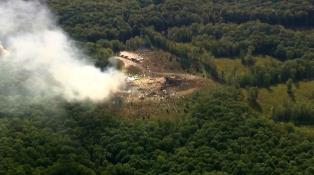 Smoke fills the air as debris covers the ground and vehicles after a powerful blast ripped through a military explosives manufacturing plant in Hickman County, Tenn., on Friday, Oct. 10, 2025. (WTVF-TV via AP)