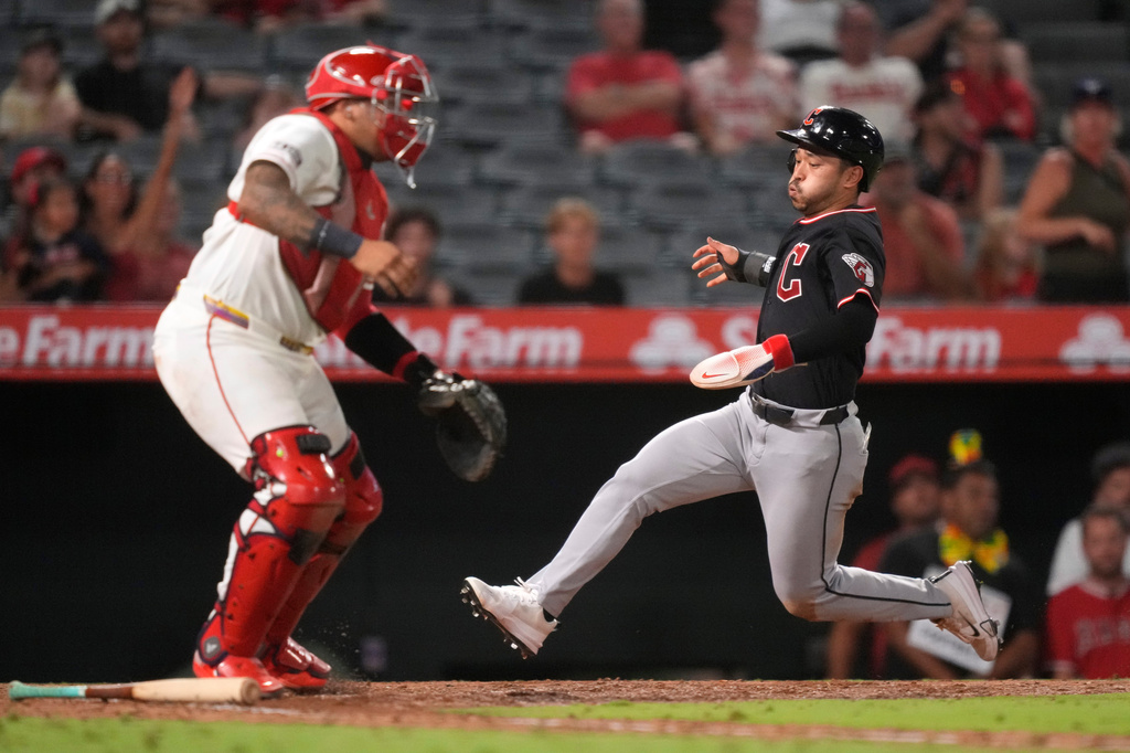 Cleveland Guardians' Steven Kwan, right, scores on a double by José Ramírez as Los Angeles Angels catcher Moisés Ballesteros stands at the plate during the 10th inning of a baseball game Tuesday, Aug. 25, 2026, in Anaheim, Calif. (AP Photo/Mark J. Terrill)