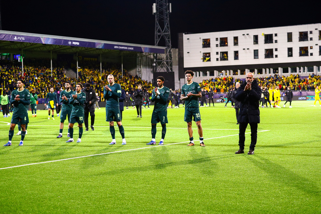 Manchester City's Erling Haaland, center, and head coach Pep Guardiola, right, applaud the crowd after the Champions League soccer match between Bodo/Glimt and Manchester City in Bodo, Norway, Tuesday, Jan. 20, 2026. (Mats Torbergsen/NTB via AP)
