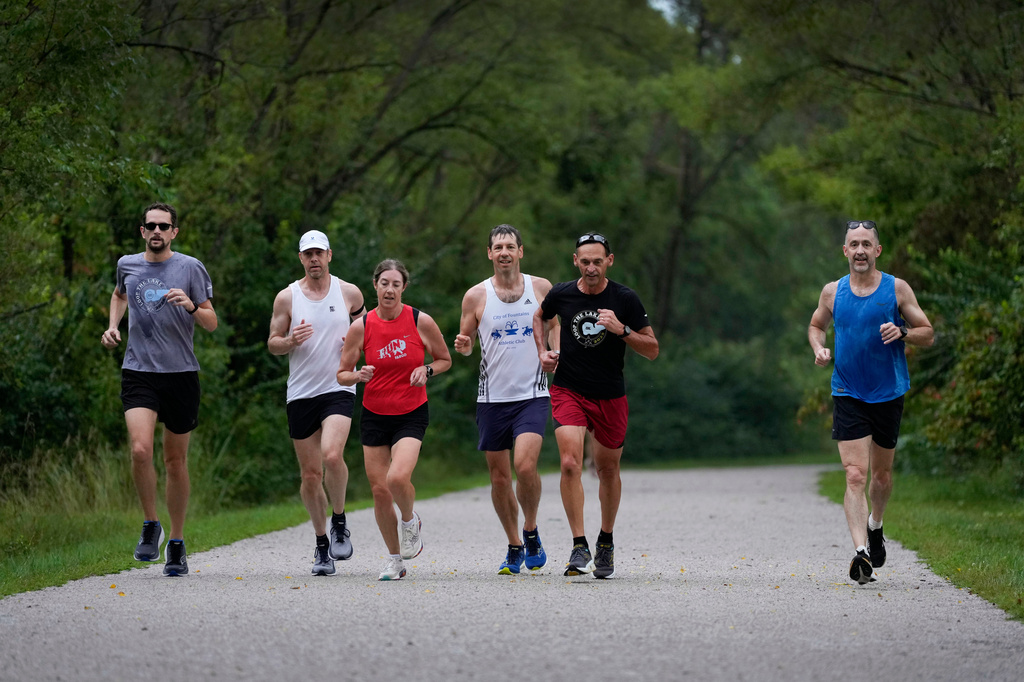 Paul Grinvalds, second from right, of West Des Moines, Iowa, trains with the Raccoon River Running Club, Sunday, Aug. 9, 2026, in West Des Moines, Iowa. (AP Photo/Charlie Neibergall)