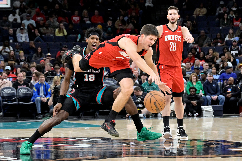 Houston Rockets guard Reed Sheppard, center, dives for the ball ahead of Memphis Grizzlies forward Olivier-Maxence Prosper (18) and center Alperen Sengun (28) in the first half of an NBA basketball game Friday, March 27, 2026, in Memphis, Tenn. (AP Photo/Brandon Dill)