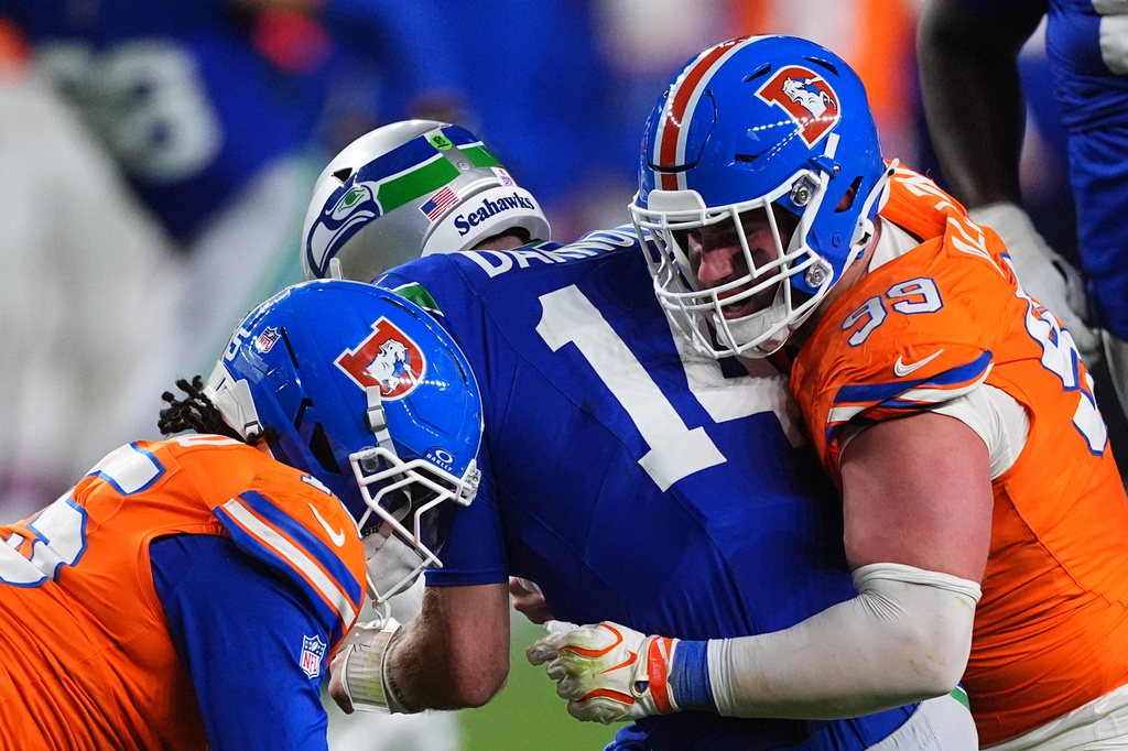 Denver Broncos defensive end Zach Allen (99) sacks Seattle Seahawks quarterback Sam Darnold (14) with Broncos linebacker Nik Bonitto, left, during the second half of an NFL football game in Denver, Thursday, Oct. 15, 2026. (AP Photo/David Zalubowski)
