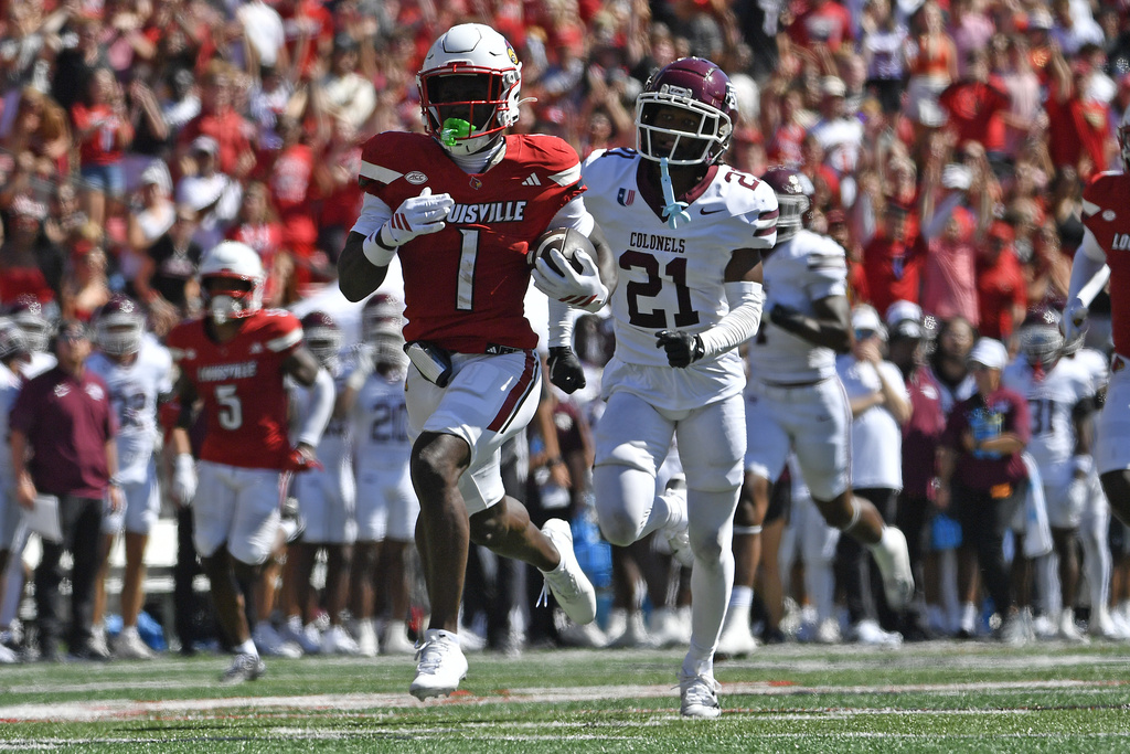 Louisville running back Isaac Brown (1) runs from the pursuit of Eastern Kentucky defensive back Rishad Hence (21) during the first half of an NCAA college football game in Louisville, Ky., Saturday, Aug. 30, 2025. (AP Photo/Timothy D. Easley)