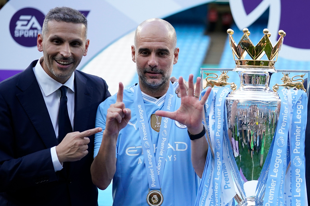 FILE - Manchester City's head coach Pep Guardiola, right, and Manchester City chairman Khaldoon Al Mubarak celebrate with the Premier League trophy after the English Premier League soccer match between Manchester City and West Ham United at the Etihad Stadium in Manchester, England, Sunday, May 19, 2024. Manchester City clinched the English Premier League on Sunday after beating West Ham in their last match of the season. (AP Photo/Dave Thompson, File)