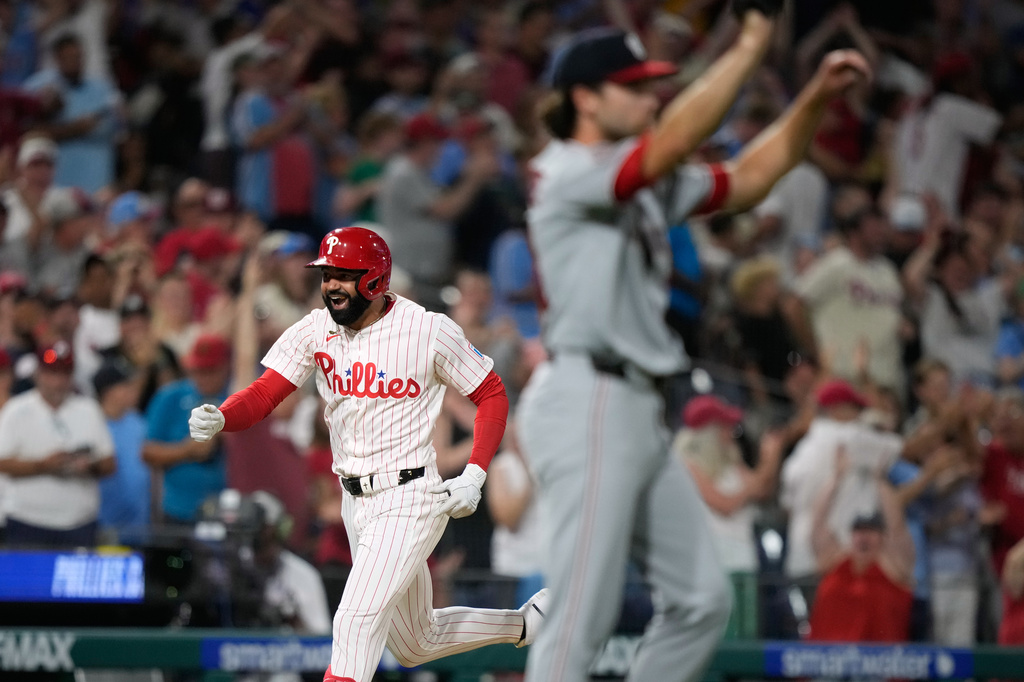 Philadelphia Phillies' Derek Hill, left, reacts after hitting a grand slam against Washington Nationals pitcher Tom Cosgrove during the seventh inning of a baseball game Monday, Aug. 3, 2026, in Philadelphia. (AP Photo/Matt Slocum)