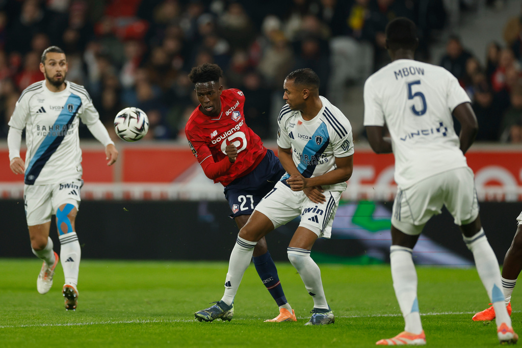Lille's Felix Correia, center left, plays the ball during the French League One soccer match between Lille and Paris FC in Lille, France, Sunday Nov. 23, 2025. (AP Photo/Jean-Francois Badias)