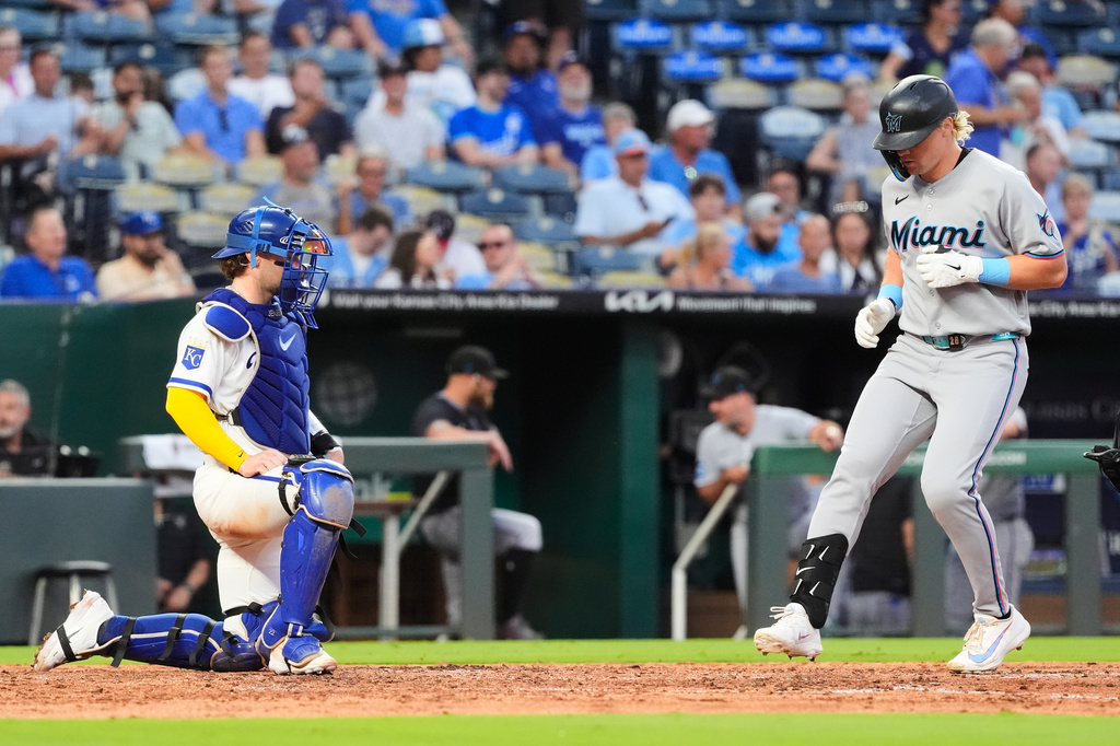 Miami Marlins' Kyle Stowers, right, crosses the plate to score after hitting a solo home run during the fifth inning of a baseball game against the Kansas City Royals, Tuesday, Sept. 1, 2026, in Kansas City, Mo. (AP Photo/Charlie Riedel)