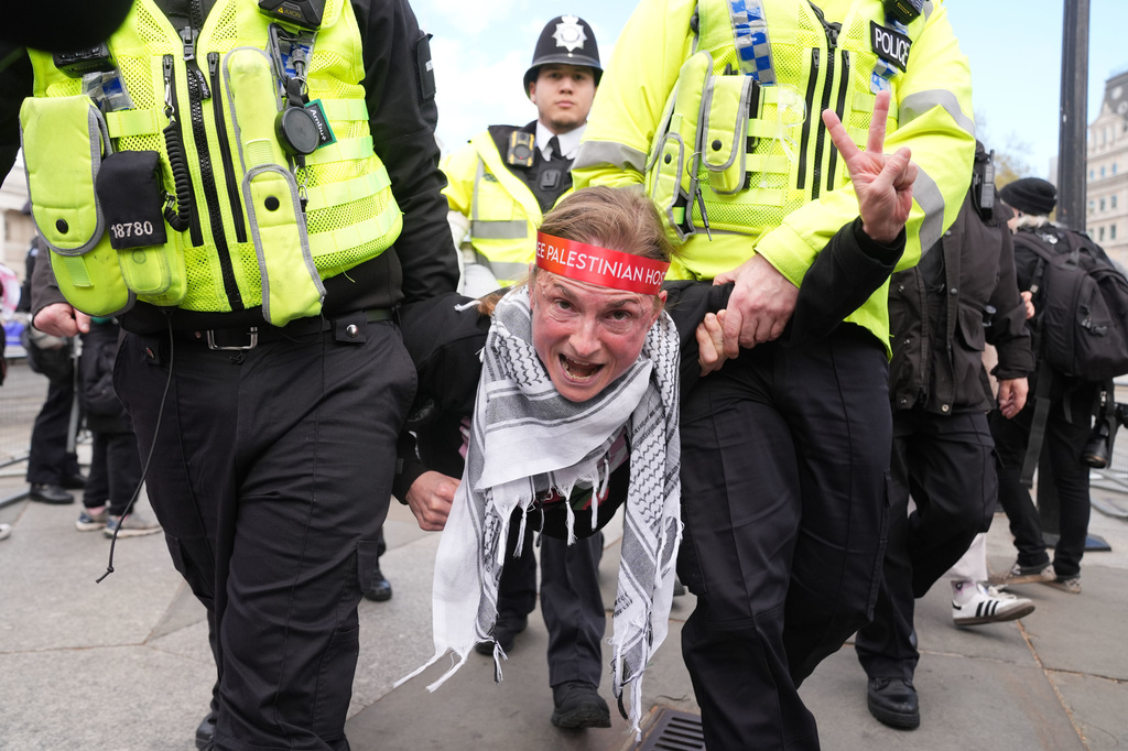 Police remove a protester at a demonstration against the ban on Palestine Action, in Trafalgar Square, central London, Saturday April 11, 2026. (Lucy North/PA via AP)