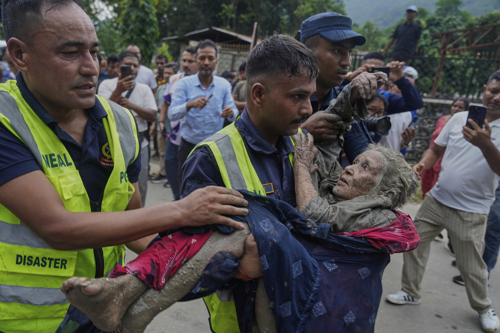 Rescuers carry a victim of flash flooding to safety along the Trishuli River in Nepal's Nuwakot district, Wednesday, Aug. 26, 2026. (AP Photo/Niranjan Shrestha)