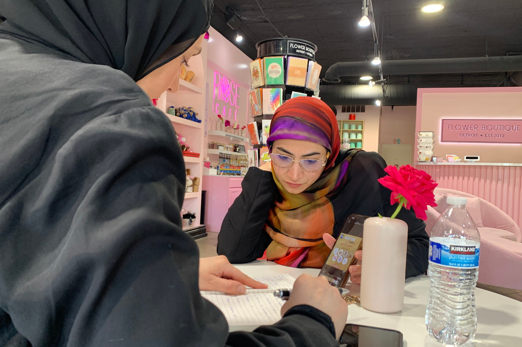 Maya Attoui, left, and Marwa Mussa discuss plans for a fundraiser while seated at a coffee shop on May 29, 2026, in Dearborn, Mich. (AP Photo/Mike Householder)