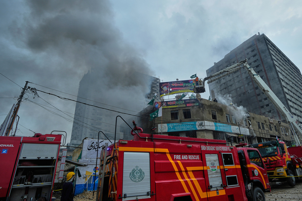 Firefighters try to extinguish a fire following an explosion at a fireworks storage facility, in Karachi, Pakistan, Thursday, Aug. 21, 2025. (AP Photo/Fareed Khan)