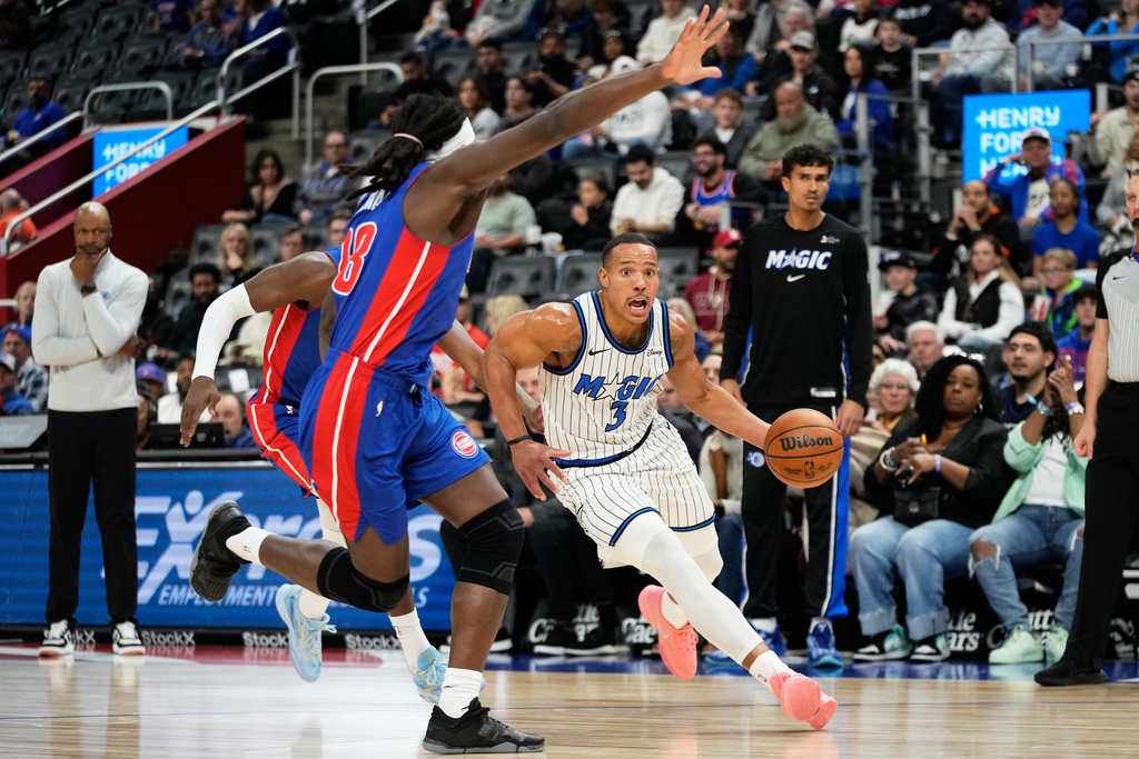 Orlando Magic guard Desmond Bane, right, drives against Detroit Pistons guard Caris LeVert, left, and forward Isaiah Stewart during the first half of an NBA basketball game Wednesday, Oct. 29, 2025, in Detroit. (AP Photo/Ryan Sun)