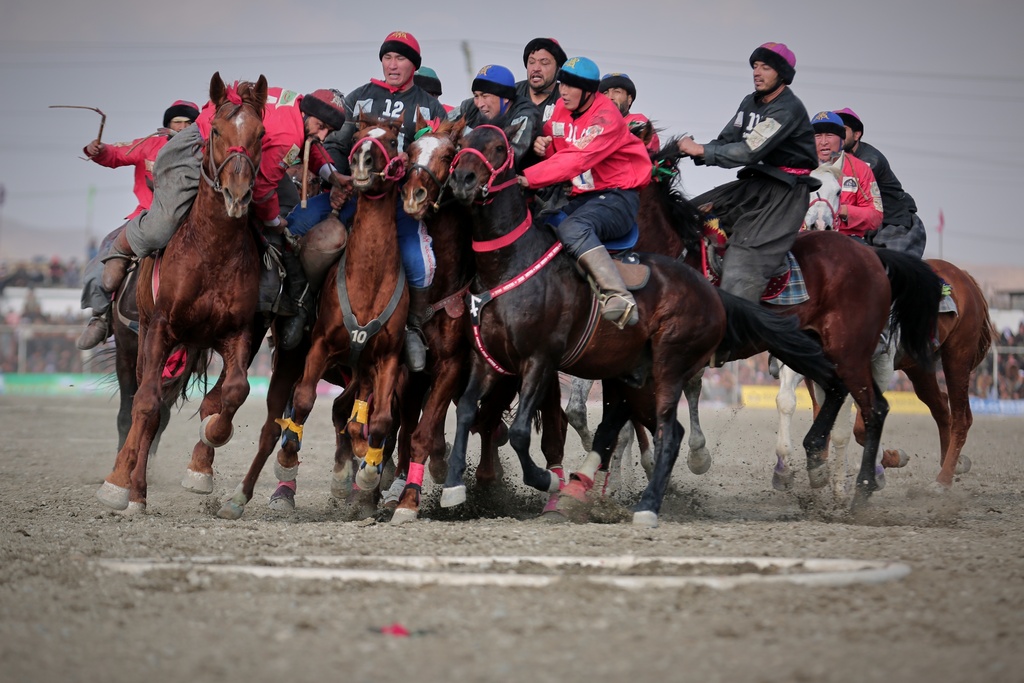 Riders from the Sar-e-Pul and Badakhshan teams compete in the final of Afghanistan's annual buzkashi tournament, a traditional equestrian sport in which riders score points using a fake goat carcass, on the outskirts of Kabul, Afghanistan, Monday, Dec. 22, 2025. (AP Photo)